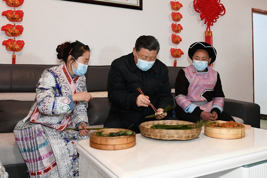 2021年2月3日下午，習近平在貴州畢節(jié)市黔西縣新仁苗族鄉(xiāng)化屋村苗族村民趙玉學家，同一家人邊聊家常邊制作當?shù)貍鹘y(tǒng)節(jié)日食品黃粑。新華社記者 李學仁 攝