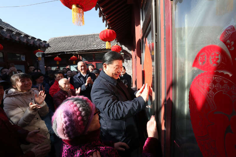 2019年2月1日上午，習近平在北京前門東區(qū)草廠四條胡同32號院，高興地拿起一幅“福”字，親自貼到門上，給這里的老街坊們拜年。新華社記者 鞠鵬 攝