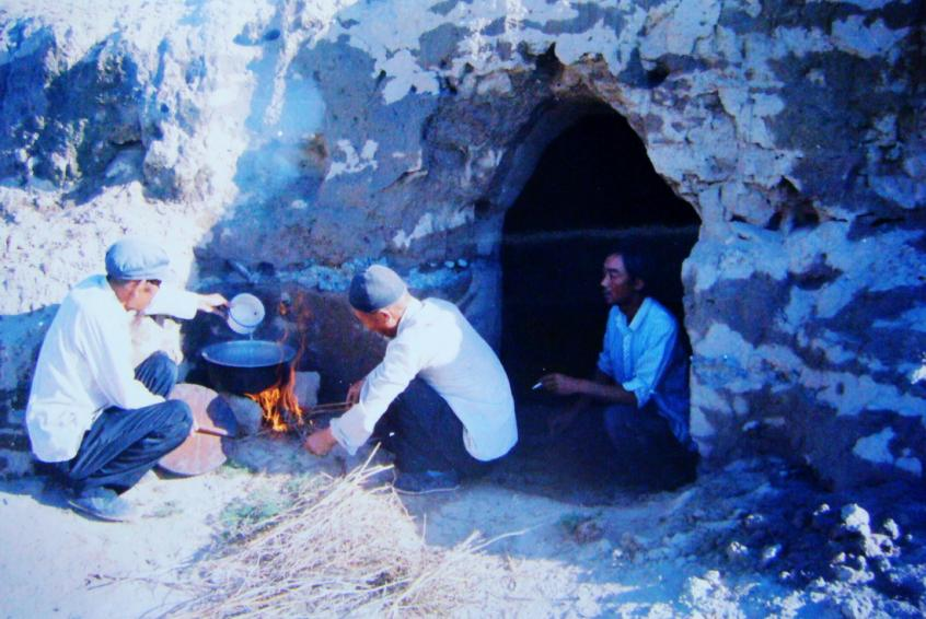 1983年，“六老漢”一代治沙人在“地窩子”生活做飯。新華社發(fā)（八步沙林場供圖）